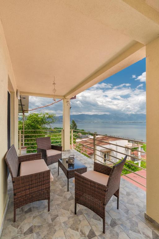 a patio with chairs and tables and a view of the ocean at Apartments by Proshevi in Star Dojran