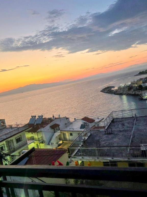 a view of the ocean at sunset with buildings at Pansion Panorama in Skala Marion