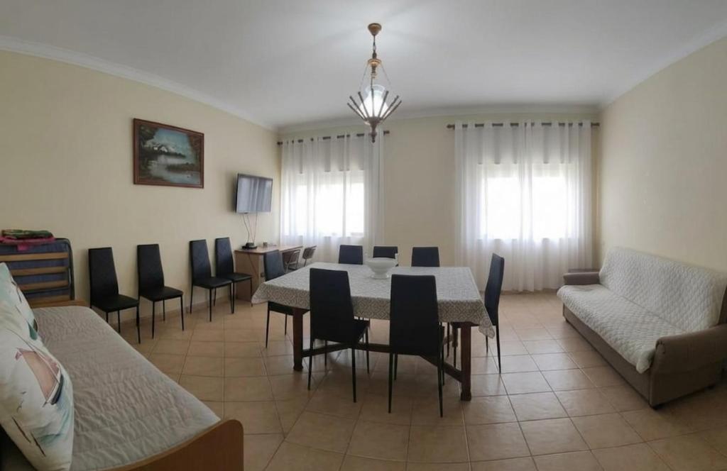 a living room with a dining room table and chairs at Gaivota Erudita in Buarcos