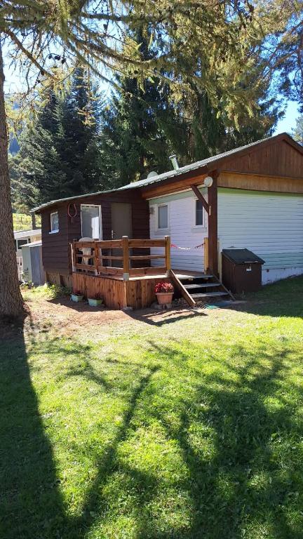 a house with a porch and a deck in the yard at Camping montagne in Camurac