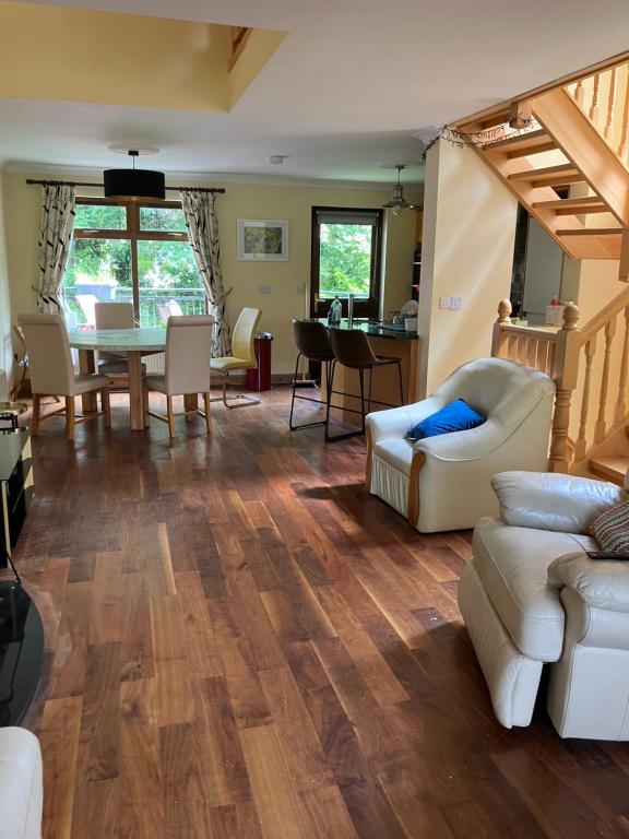 a living room with wooden floors and a table and chairs at Clifden townhouse in Clifden