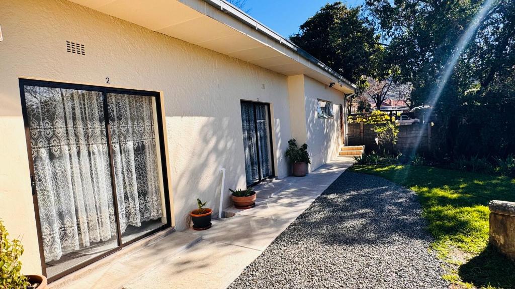 a house with a large sliding door on the side of it at Jwalaboholo Mountain View Guest House in Ficksburg