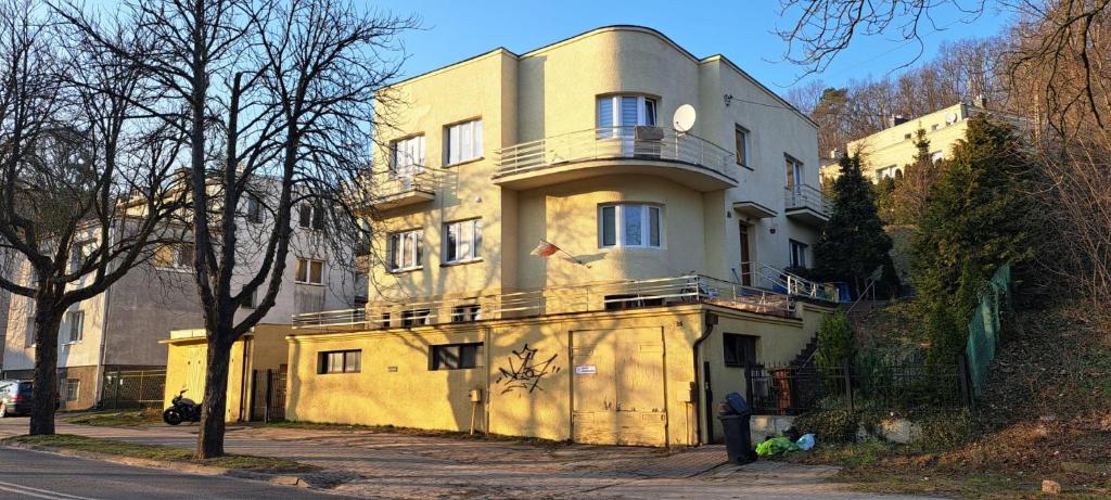 a yellow building with a balcony on top of it at Pokoje na lato Gdynia in Gdynia