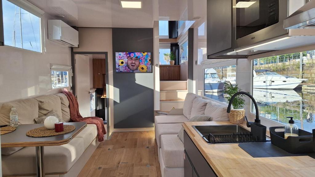 a kitchen and living room with a couch and a table at Duerme en un barco in Moaña