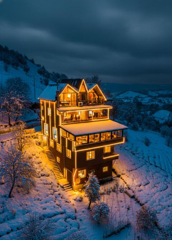 a large house in the snow at night at Seyri Alem suit villa Bungalow in Ardeşen