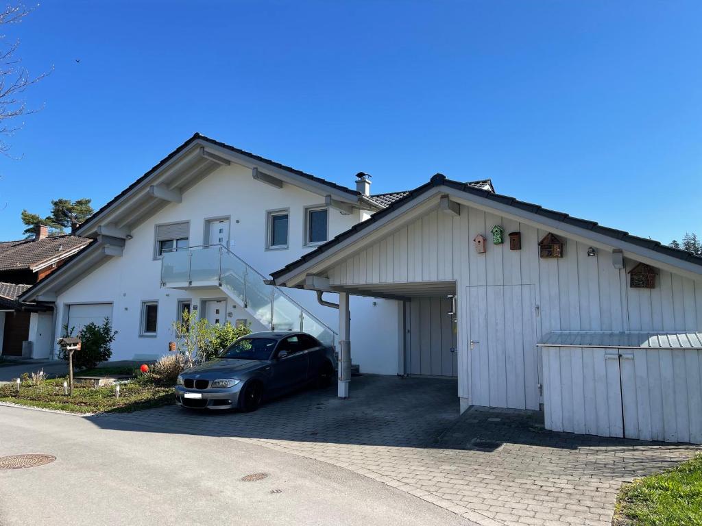 a car parked in front of a white house at Ferienwohnung Hoherting in Prien am Chiemsee
