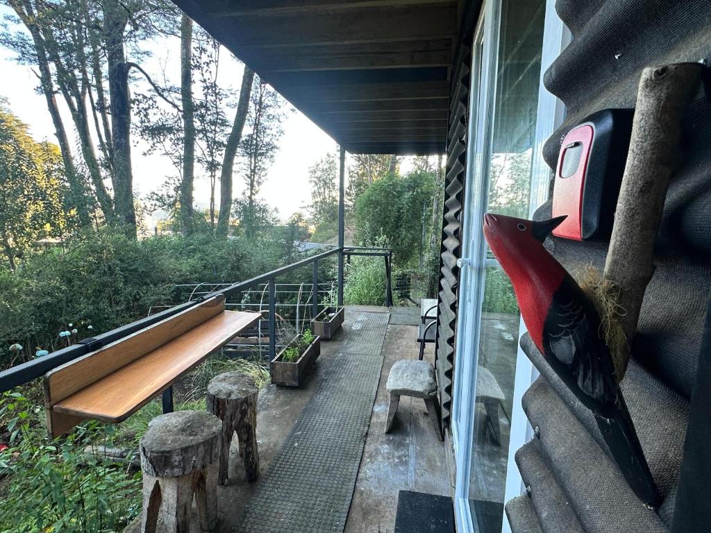 a balcony with a bench and a window at Casita Bosque-Rucalemu in Valdivia