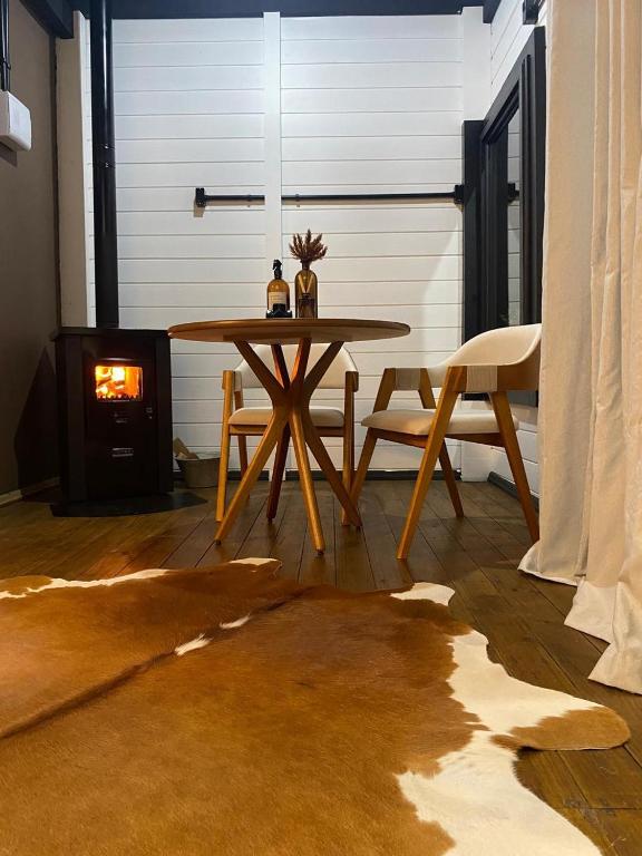 a table and chairs in a room with a fireplace at NOVIDADE - Cabana Refúgio Gaia in Annitapolis