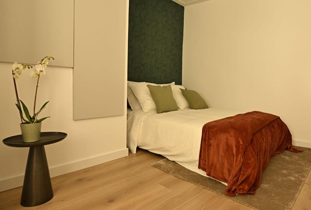a bedroom with a bed and a table with a vase at Le Cocon de Pommard in Pommard