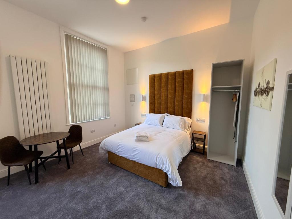 a bedroom with a bed and a table with chairs at Fishergate Residences in Preston