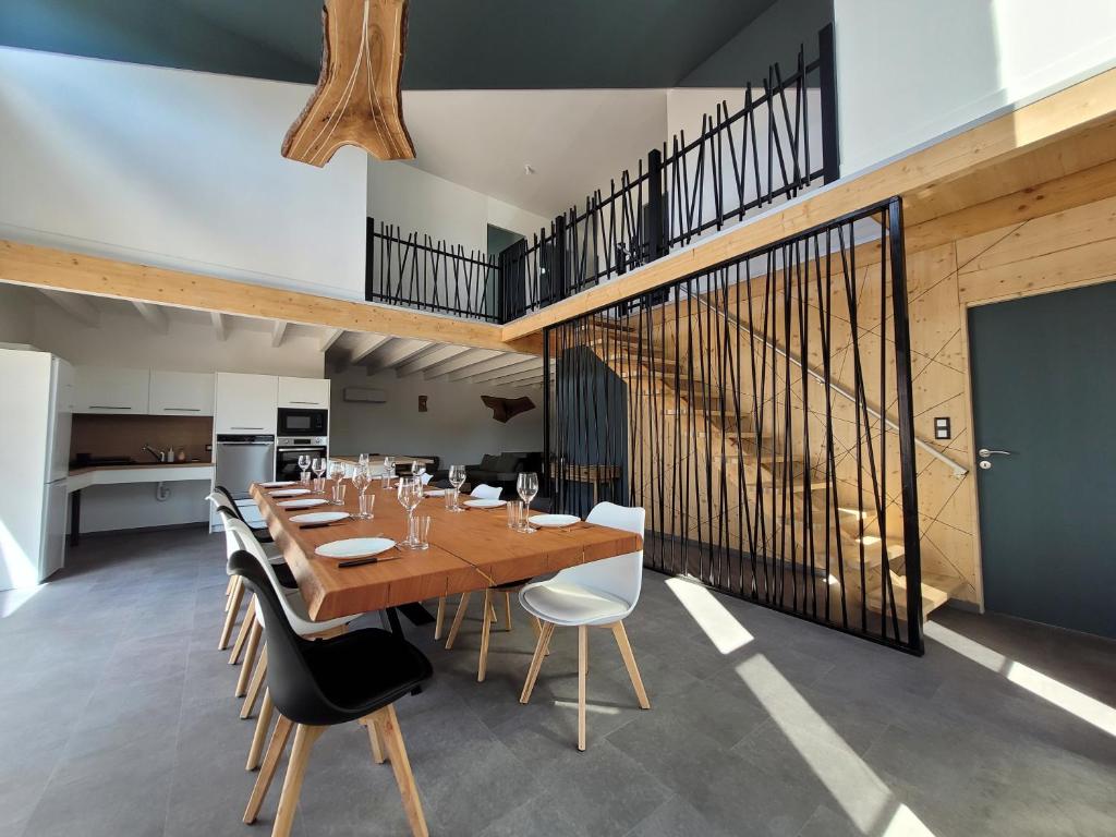 a dining room with a wooden table and chairs at Les écuries in Secondigny