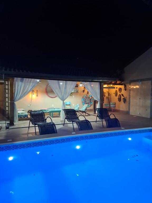 a pool with chairs and a table in a building at Recanto dos Guimarães in Palhoça