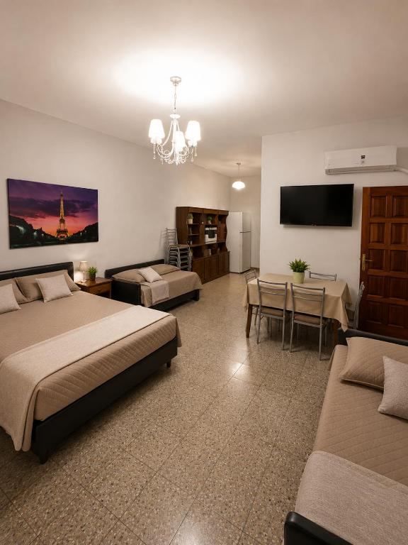 a hotel room with two beds and a living room at La Casa de Miel in Villa Ballester