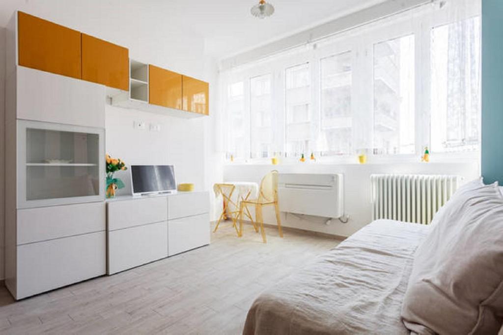 1 dormitorio blanco con 1 cama y cocina en Riva Reno Apartment, en Bolonia