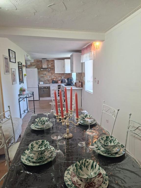 a dining room table with plates and red candles on it at Romantic house by the River in Pfaffenhoffen