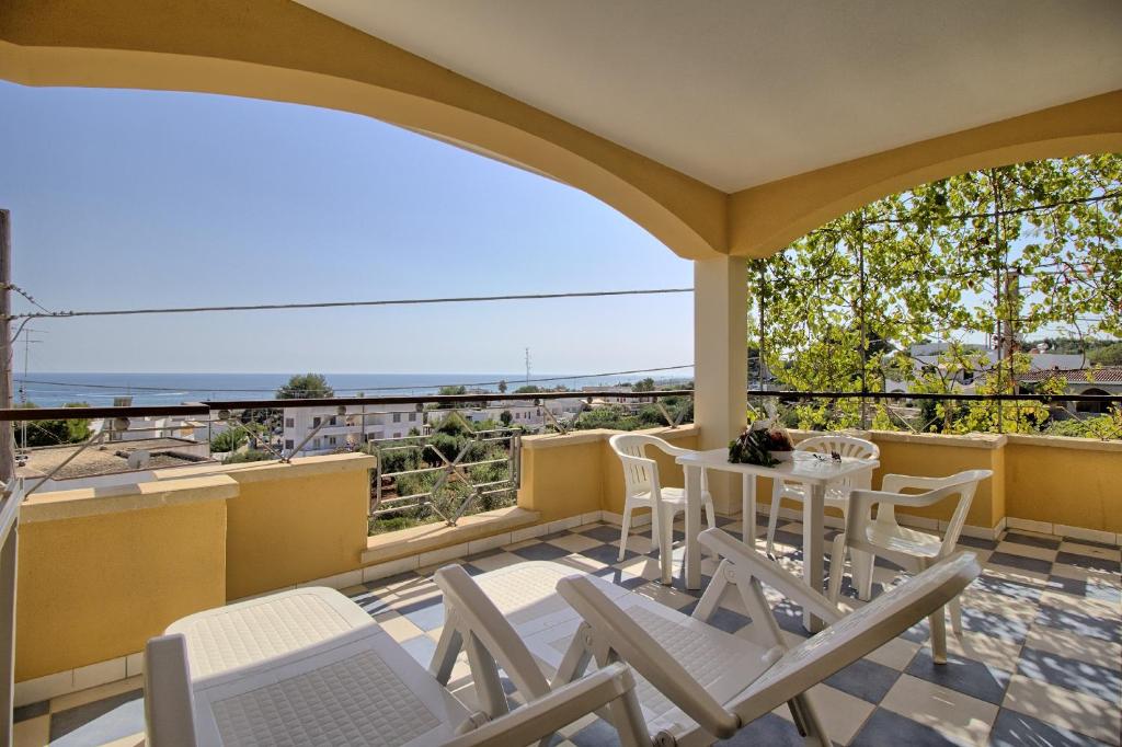un patio con sedie e un tavolo sul balcone. di Mansarda Canarina a Marina di Pescoluse