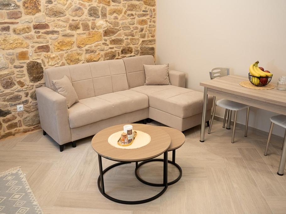 a living room with a couch and a table at Meltemi Apartment in Chios