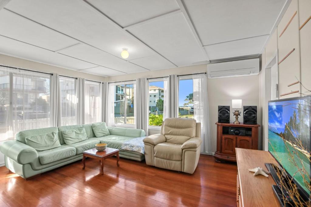 a living room with a couch and a chair at Kitchener Street 2, Golden Beach in Golden Beach