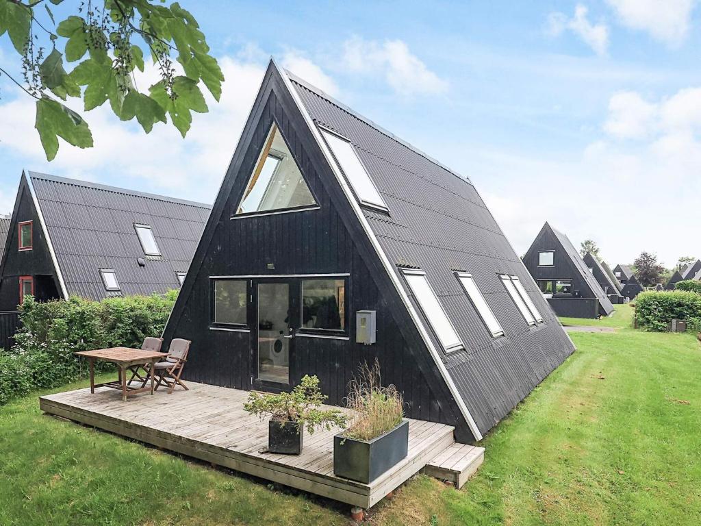a black house with a deck and a table at 4 star holiday home in Farsø in Farsø