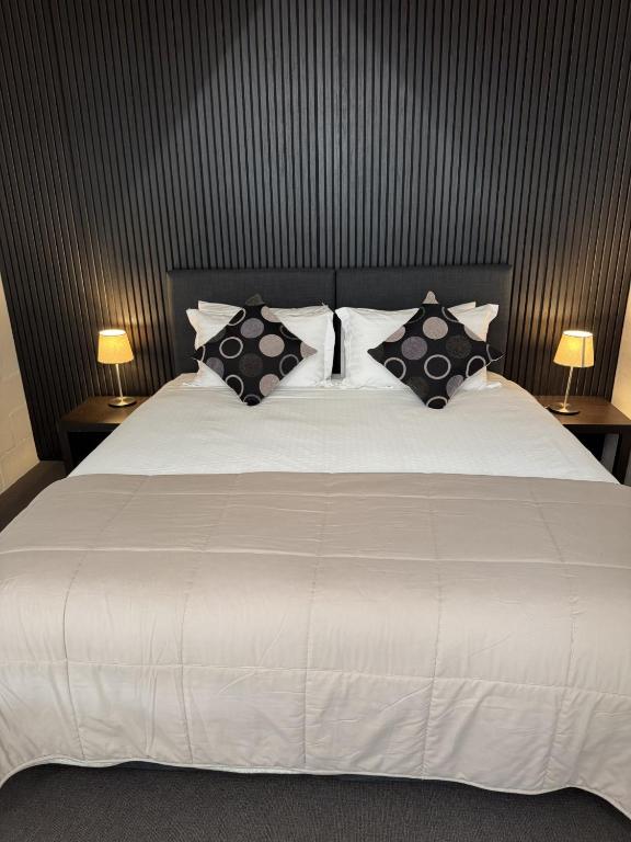 a bedroom with a white bed with pillows at Summit Ridge Alpine Lodge in Falls Creek