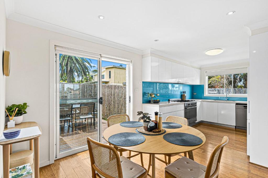 a kitchen and dining room with a table and chairs at Mariners in the Village in Shellharbour