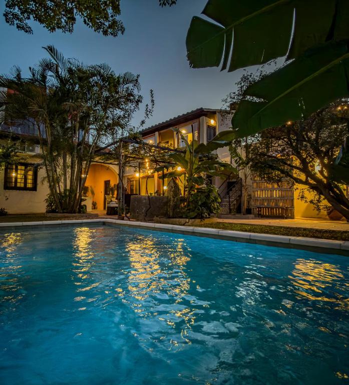 a swimming pool in front of a house at night at Casa El Jardín Centro Histórico in Asunción