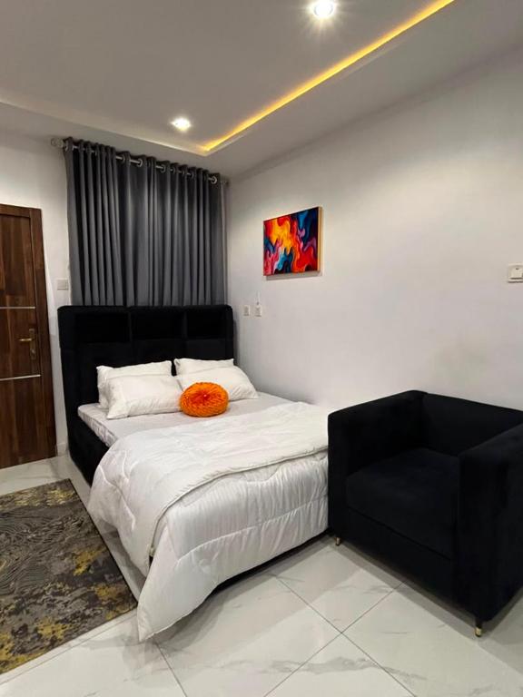 a bedroom with a bed with a orange pillow on it at Abadel Homes in Ikeja