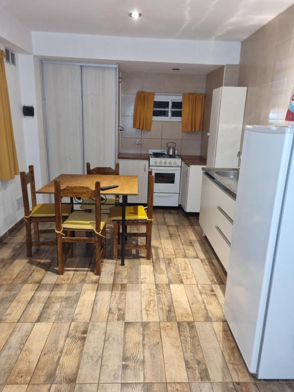 a kitchen with a table and chairs and a refrigerator at El Encuentro in Sierra de los Padres