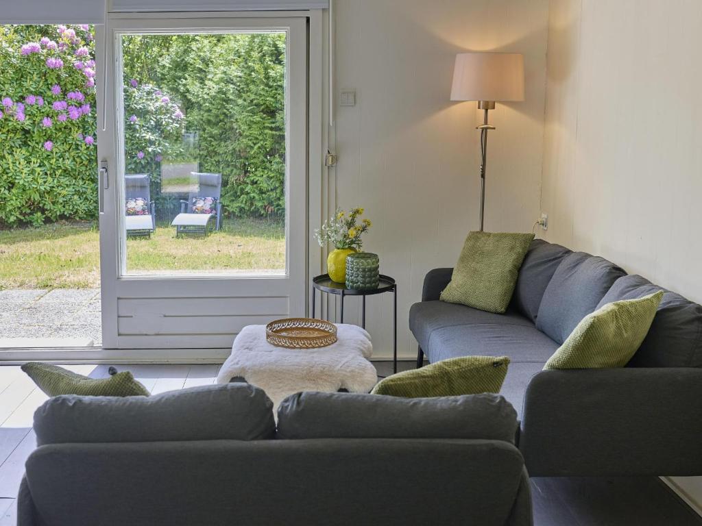 a living room with two couches and a window at Brabants licht in Lage Mierde