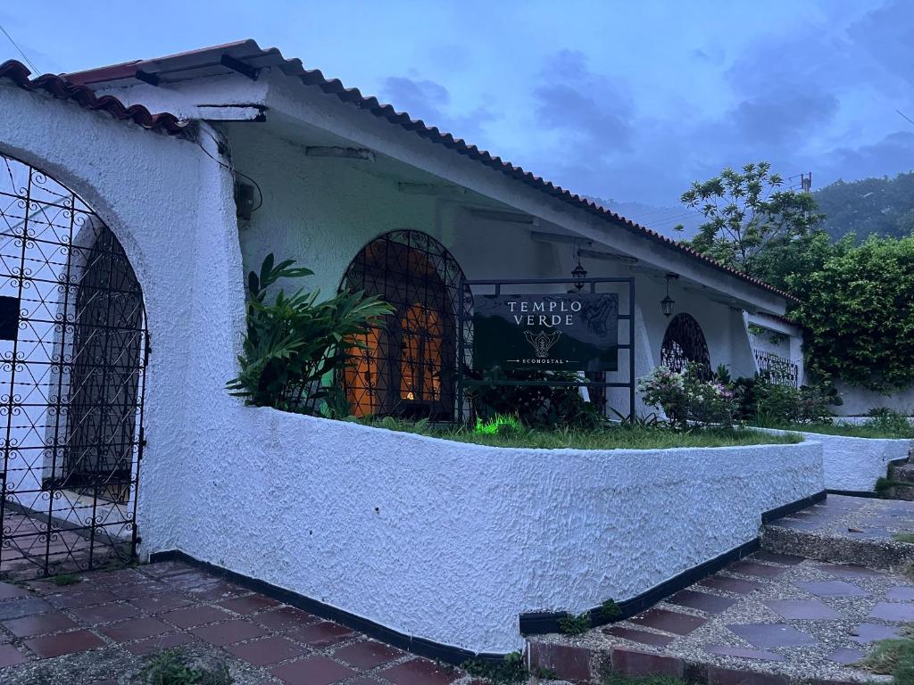 a building with a sign on the side of it at Templo Verde Eco hostal in Minca