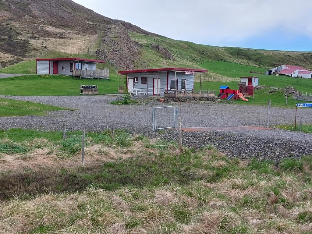 a couple of small houses on a hill at Ásbrandsstadir Cottages in Vopnafjörður
