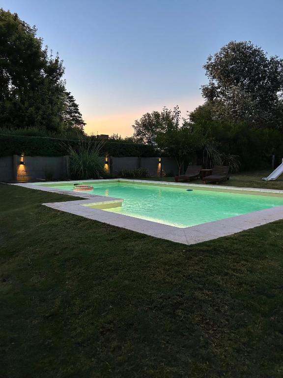 a swimming pool in the middle of a yard at La Casita de la Granja, Casa con Pileta Y Gran Parque in La Granja