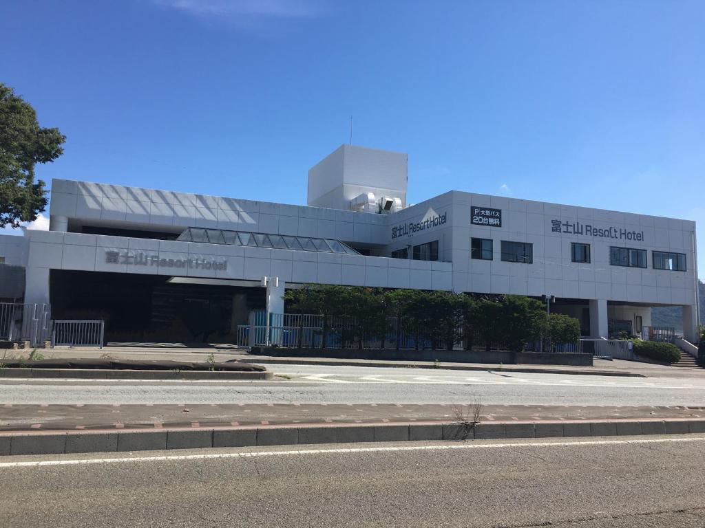 a large white building with a road in front of it at Fuji Mountain Resort Hotel in Fujikawaguchiko