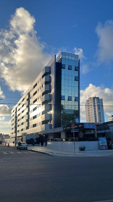 a large building with a car parked in front of it at Residencial Neo 1 in Maceió