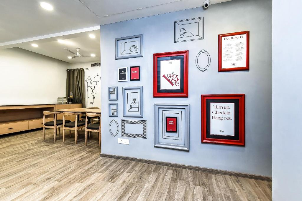 a wall with pictures on it with a table and chairs at Hotel O Noida premium inn in Noida
