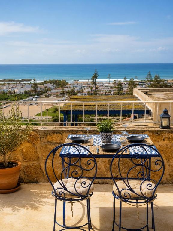 a table and chairs with a view of the ocean at Le petit château Vue sur mer Uniquement les familles in Oualidia