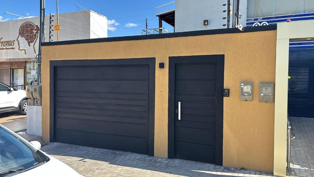 a pair of garage doors on a building at Suites Coliseu 40-A in Petrolina