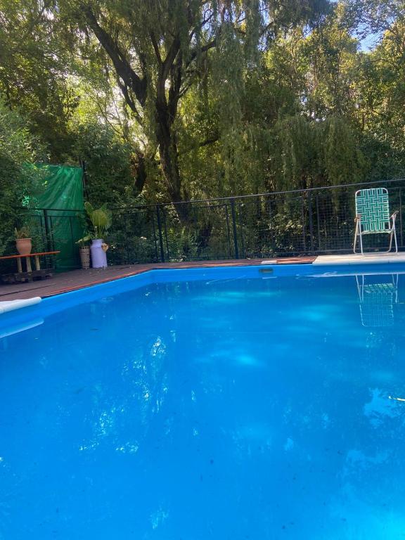 a blue swimming pool with a chair next to a fence at Siempre verde3 in Merlo