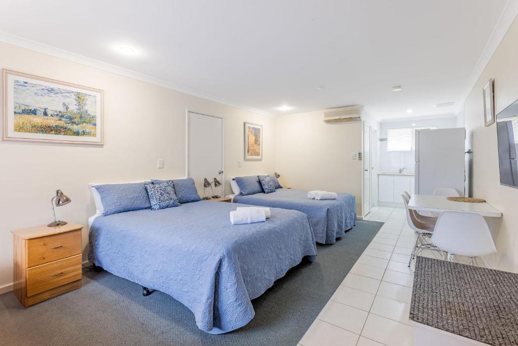a hotel room with two beds and a desk at Emu Point Motel in Albany