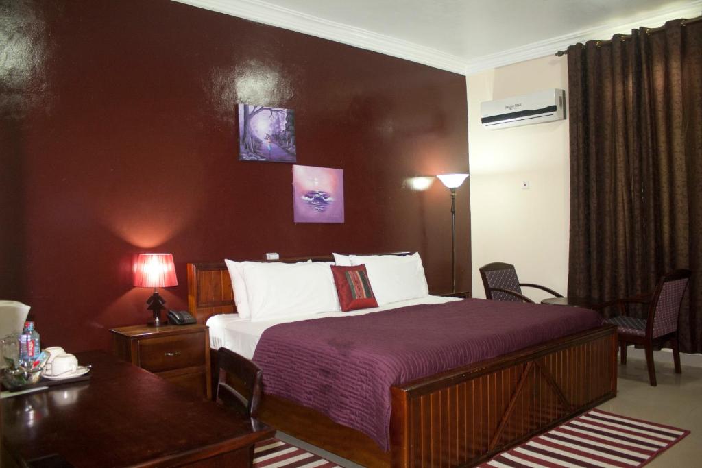فندق غراند ستار في North Legon: غرفة فندقية بسرير وطاولة وكراسي