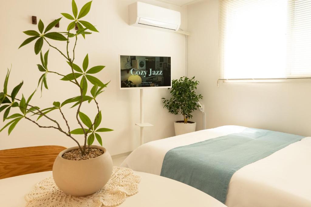 a bedroom with a plant on a table next to a bed at Danchu stay in Seoul