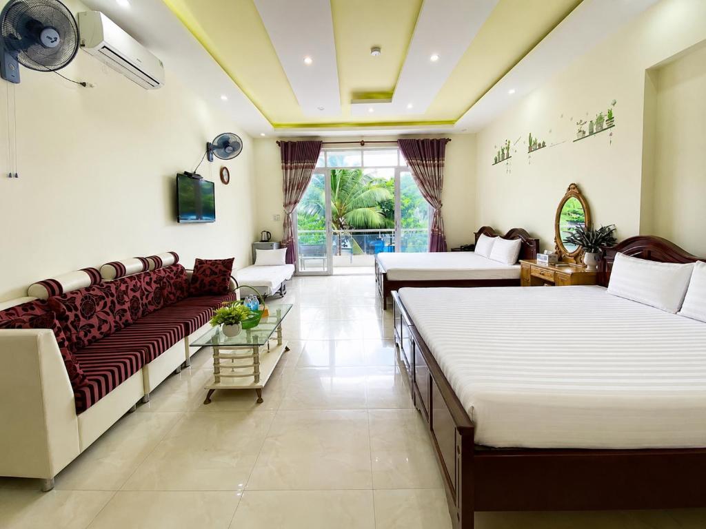 a living room with two beds and a couch at The Red Hotel Côn Đảo in Con Dao
