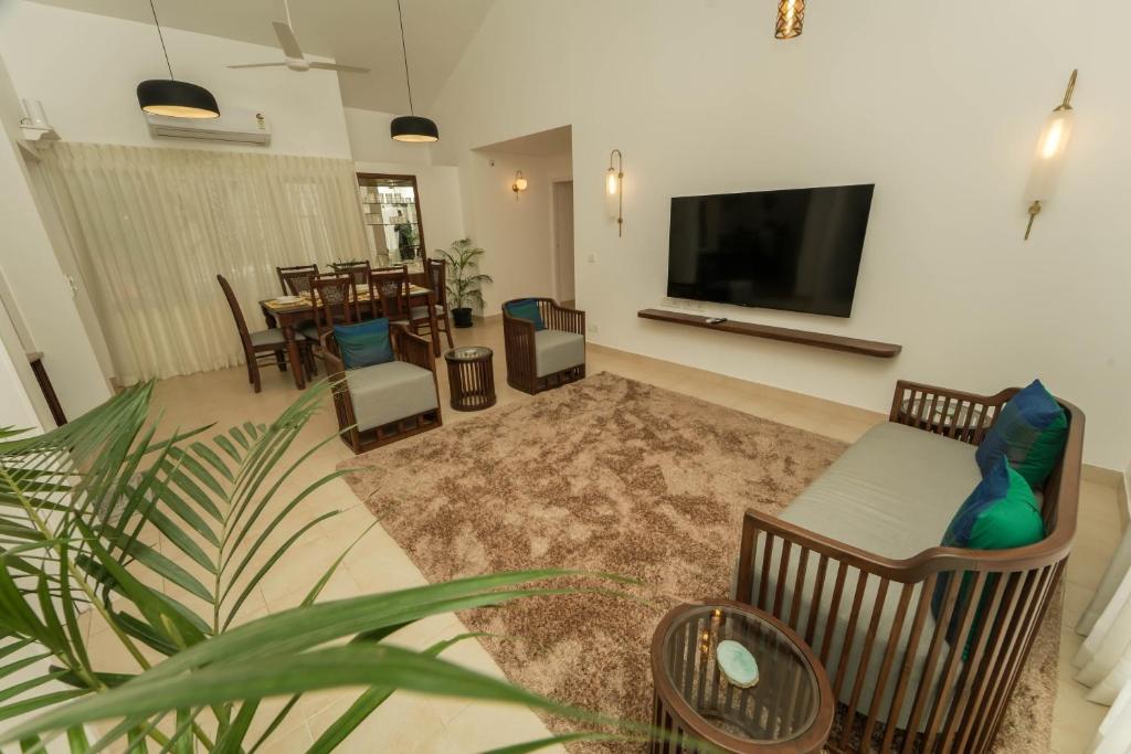 a living room with a couch and a flat screen tv at Azure Luxury 3-Bedroom Penthouse Candolim, Next to Novotel and Starbucks, close to Beach - By Lembranca in Candolim