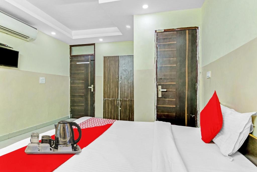 a hotel room with a bed with a tea kettle on it at Hotel O Royal Green in New Delhi