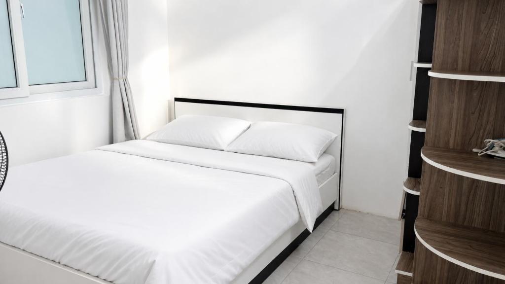 a bedroom with a bed with white sheets and a window at 1932 OC2a in Nha Trang