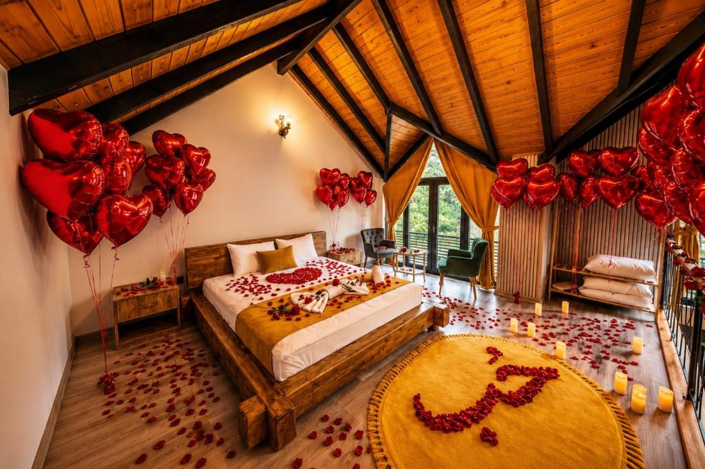 a bedroom with a bed with red roses and balloons at Villa Vrosi - فلل وأكواخ فيروز السياحية in Ardeşen