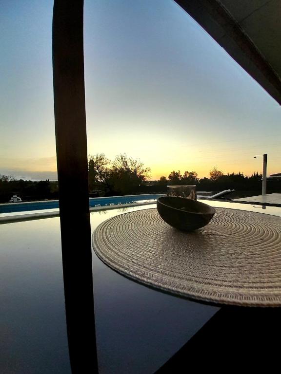 a bowl sitting on top of a table near a pool at AuraHouse Algarve in Lagoa