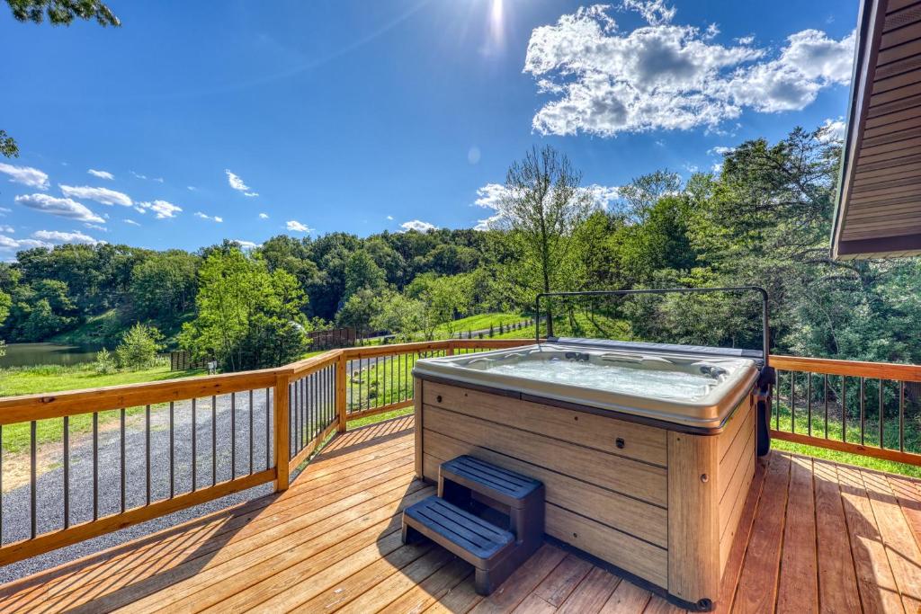 a hot tub on the deck of a house at Covea Cabin in Luray