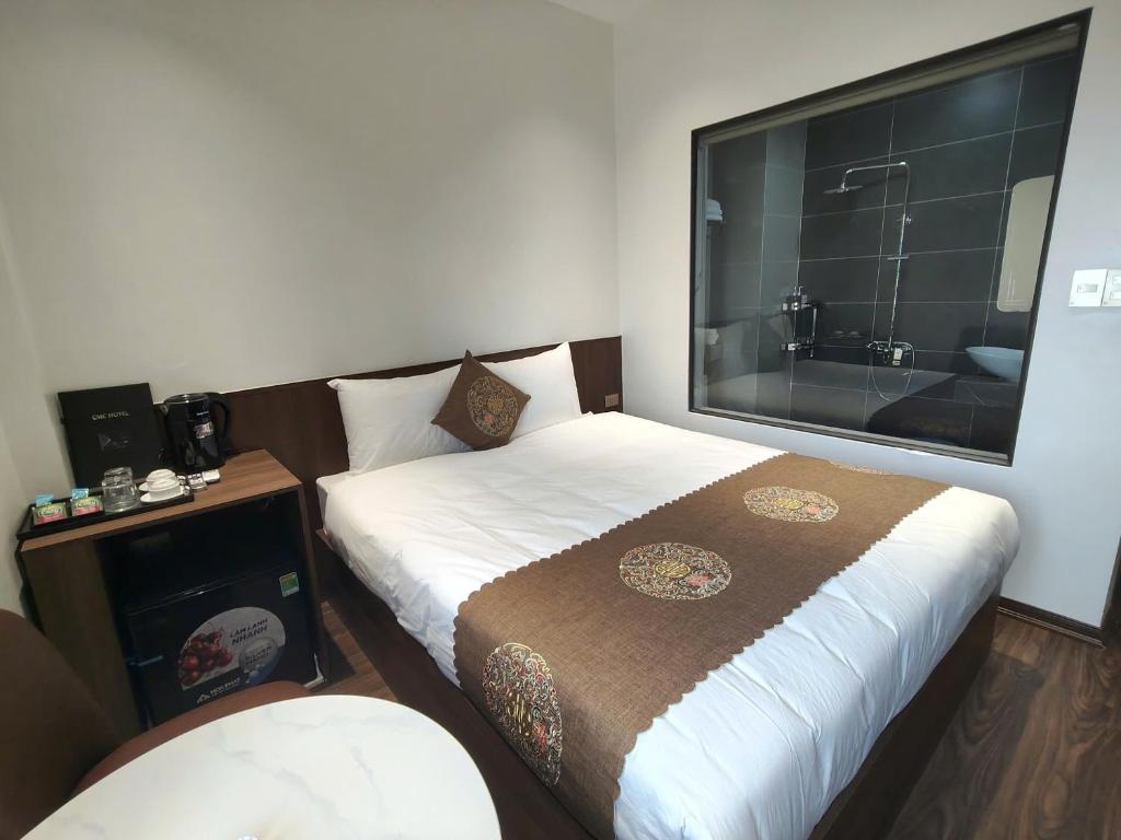 ein Hotelzimmer mit zwei Betten und einer Badewanne in der Unterkunft CMC Hotel in Bắc Giang