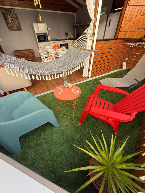 a room with a hammock and a table and chairs at Chalet du Soleil in Pointe-Noire